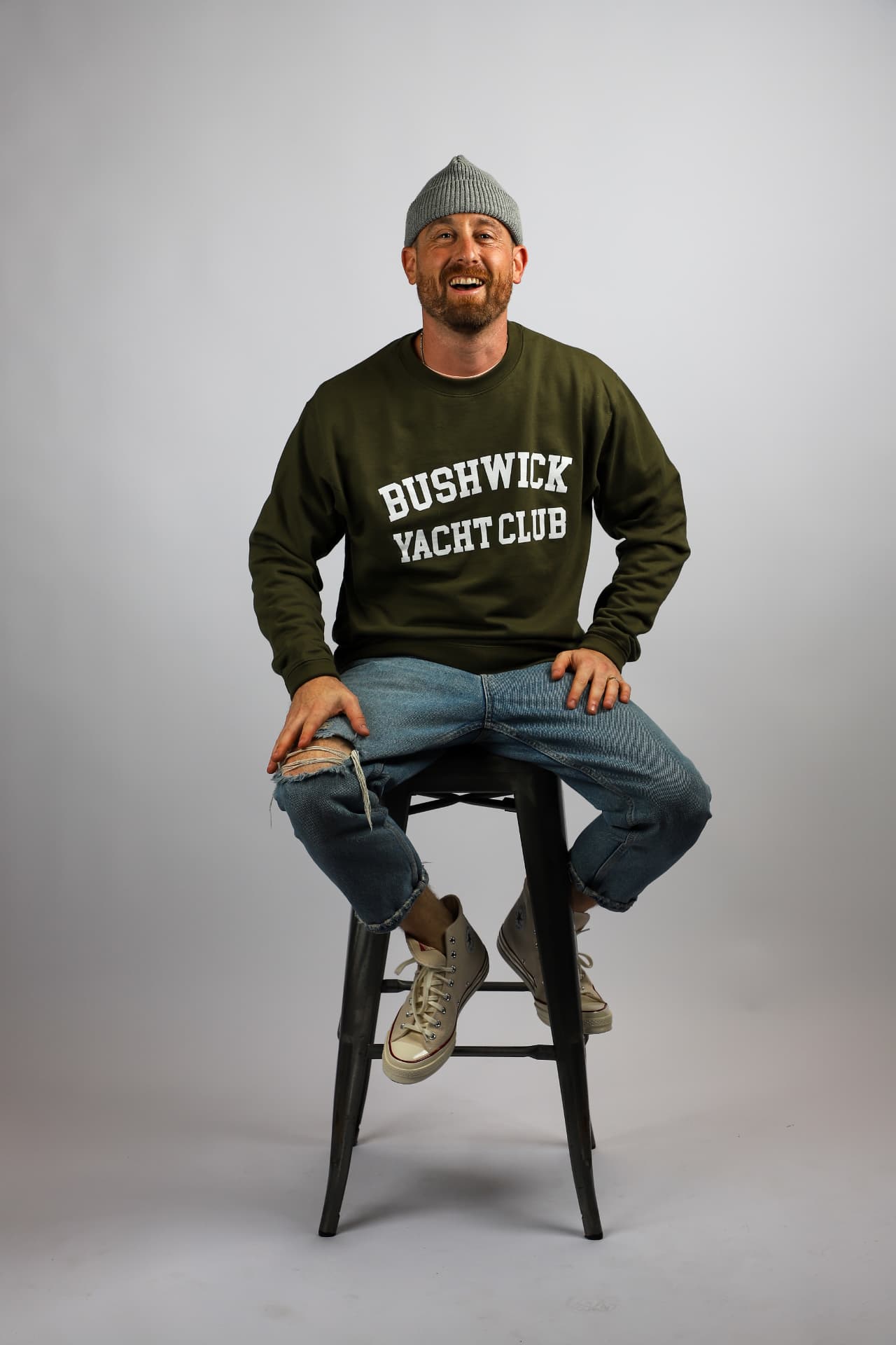 Aaron Nessel, founder of BYC Design Shop, seated on a stool in a Brooklyn studio